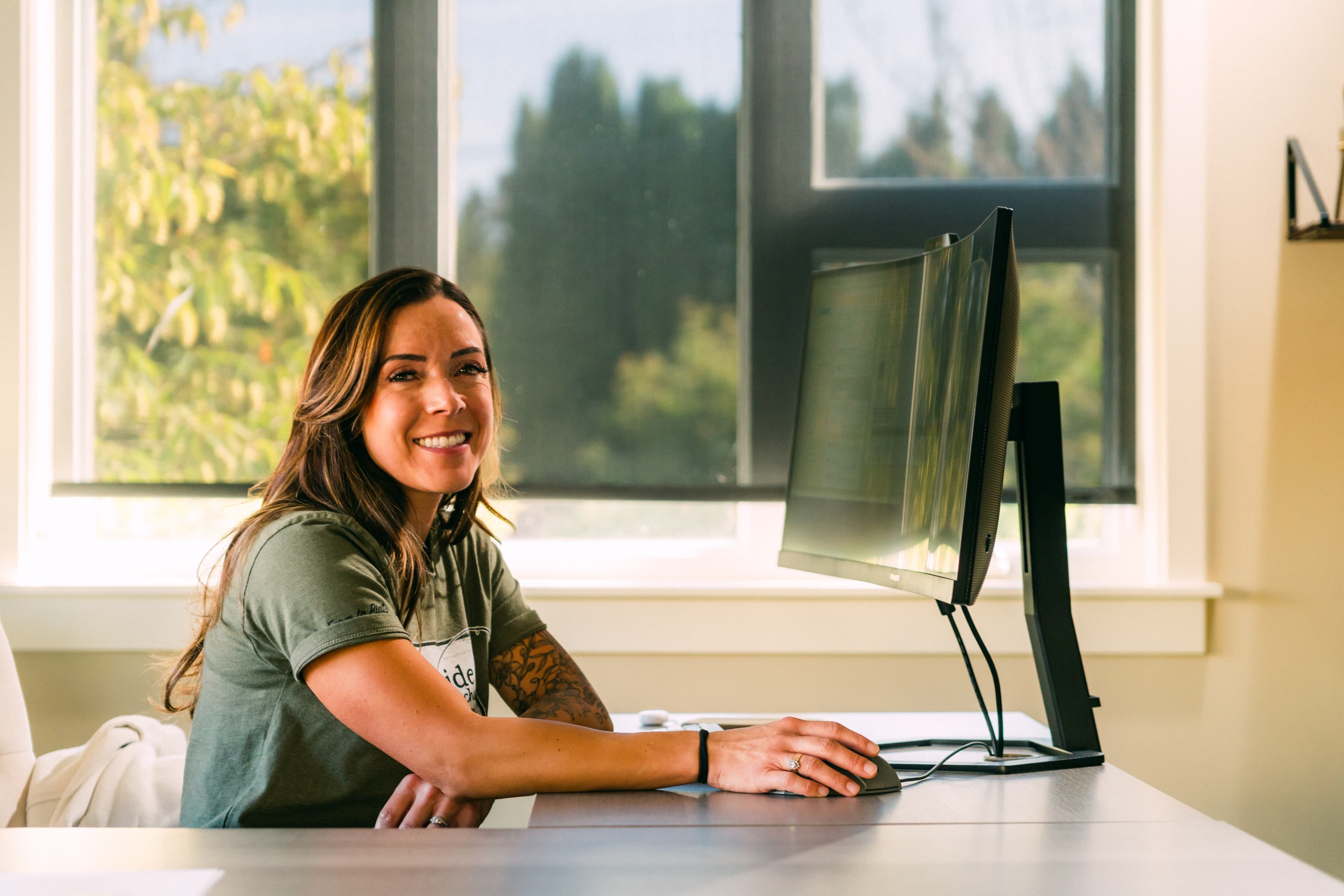 Woman grower sitting at desk in front of computer and smiling